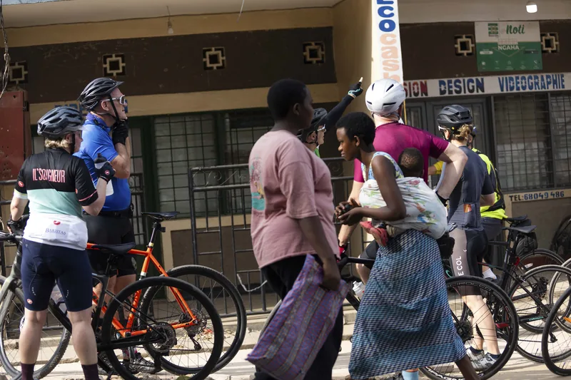 Riders threading through a busy street, people walking alongside