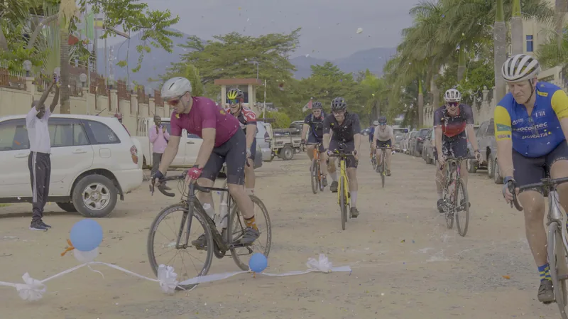The finish: riders arriving between parked vehicles and balloons